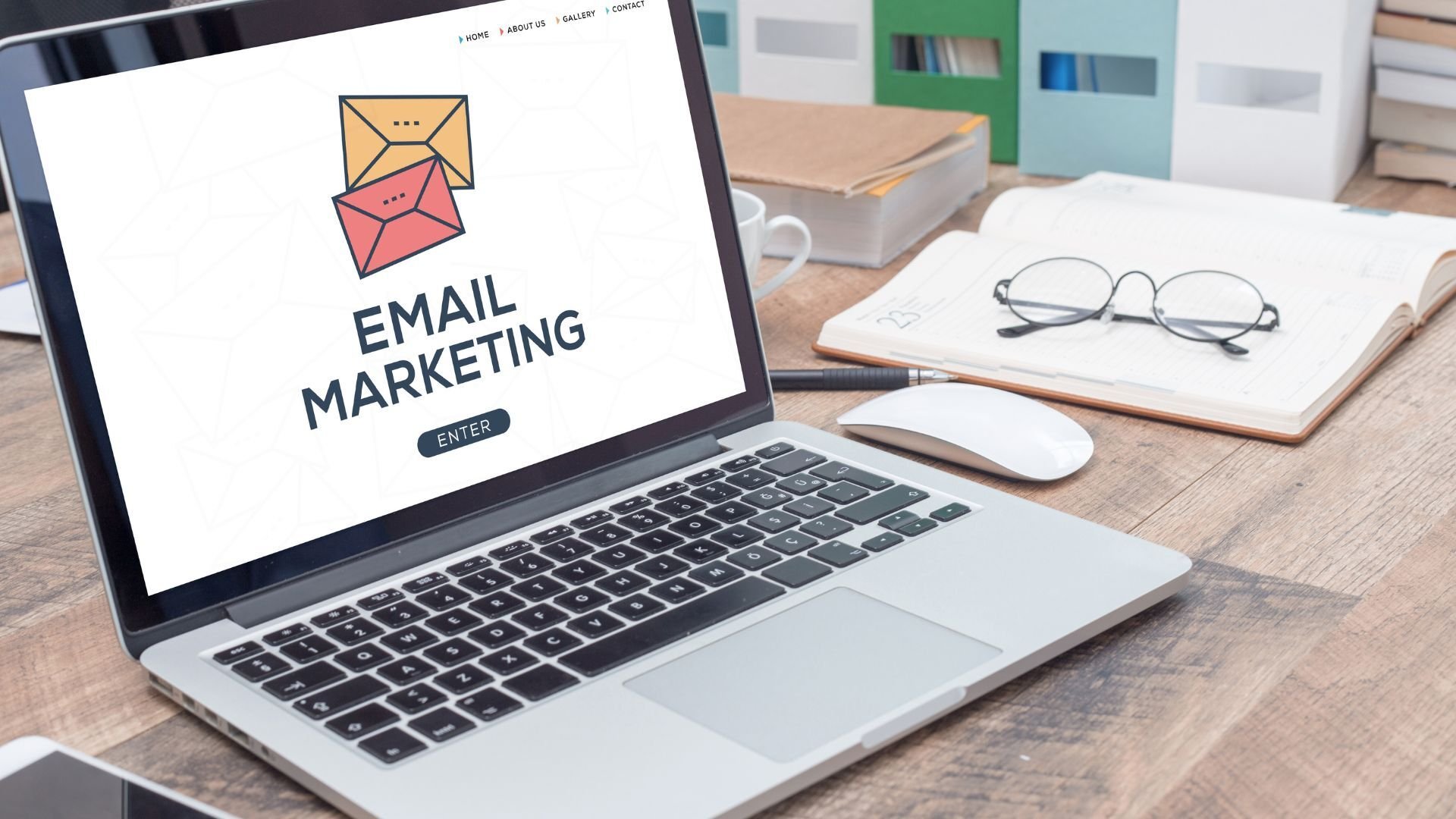 a laptop sitting on a table with the words email marketing displayed on the screen