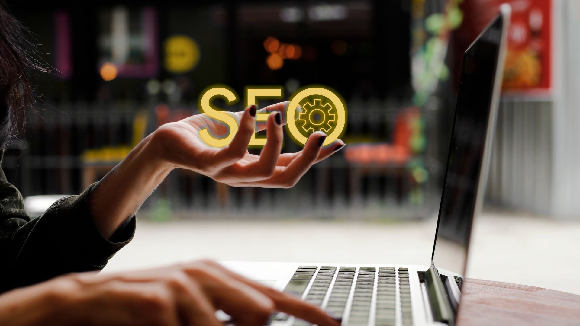 a person sitting at a computer holding the letters SEO which stands for search engine optimization