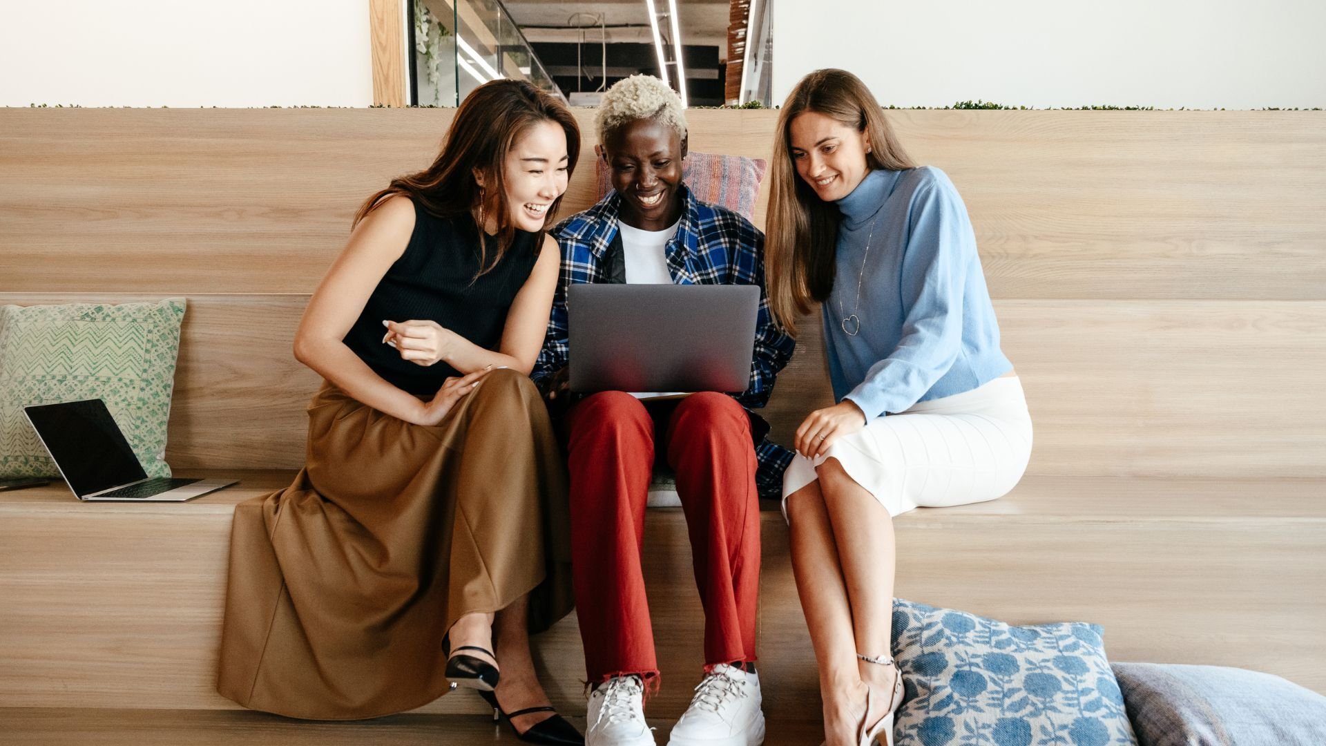 three seo agency clients sitting looking at a computer smiling
