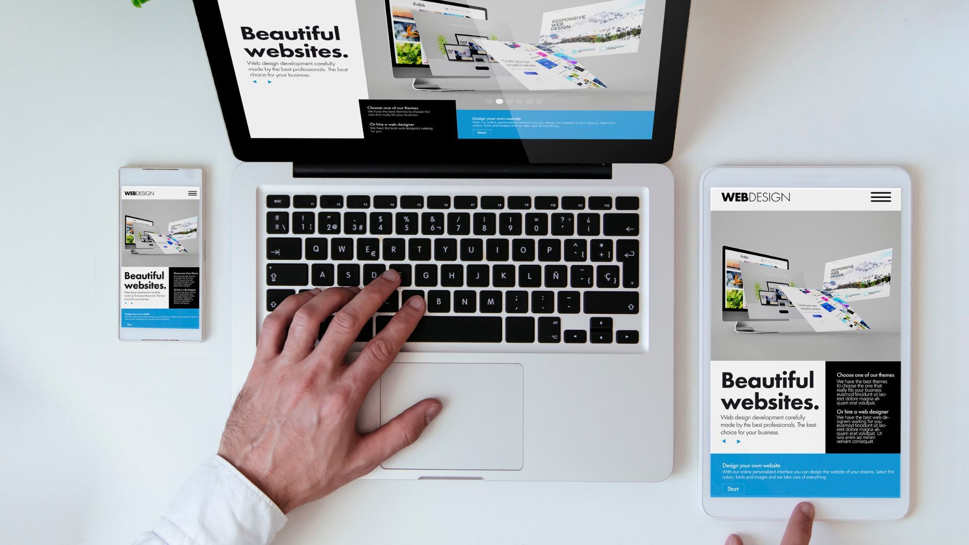 aeriel view of grey laptop with black keys, with one hand visible of the person working on the laptop